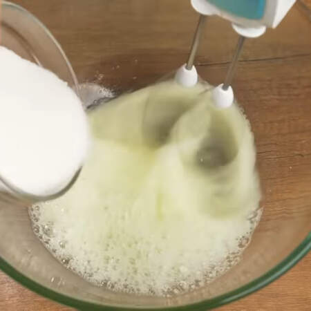 В белки добавляем щепотку соли. Белки начинаем взбивать и постепенно насыпаем 130 г сахара и 10 г ванильного сахара. 