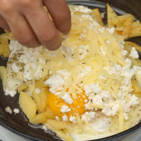 Сверху на яйца кладем 100 г творога и все посыпаем тертым сыром.