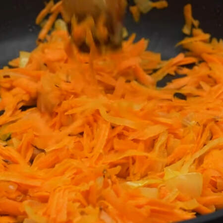 Когда лук подзолотится, добавляем к нему тертую морковь. Все пассеруем до мягкости морковки. 