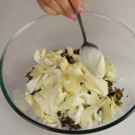 Маринованный лук и нарезанные яйца перекладываем в миску к баклажанам. Заправляем салат 2 ст. л. майонеза и перемешиваем. 