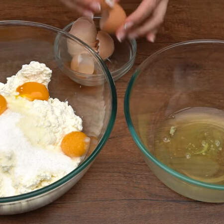 В большую миску кладем 1 кг творога, насыпаем к нему 100 г сахара и 10 г ванильного сахара.
Четыре яйца разделяем на белок и желток. Белки выливаем в чистую сухую миску, а желтки сразу же добавляем к творогу.
