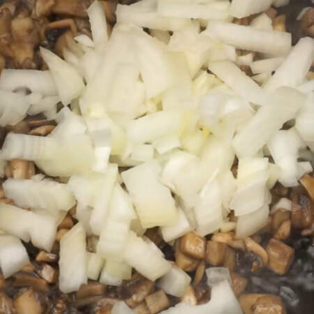 Когда из грибов испарится лишняя влага, наливаем в сковороду еще немного подсолнечного масла и сюда же добавляем лук. 
