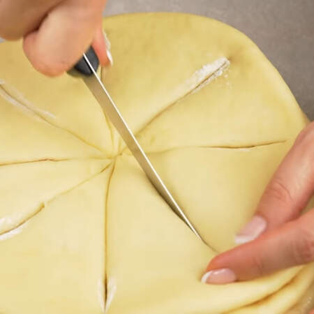 Разрезаем пирог до самого низа не разрезая край. Чтобы нож не прилипал к тесту, каждый раз макаем его в муку. Так разрезаем все части.