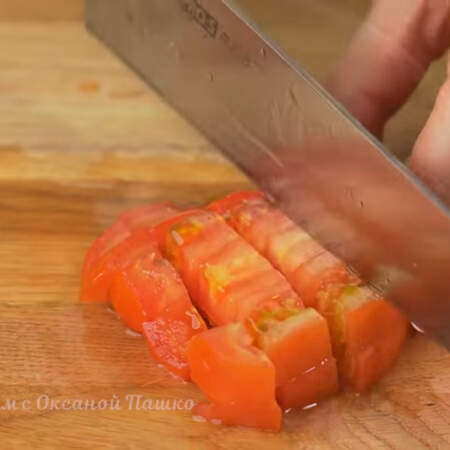 Два помидора среднего размера разрезаем пополам и вырезаем плодоножку. Помидоры тоже нарезаем сначала пластинками, а затем пластинки режем кубиками.
