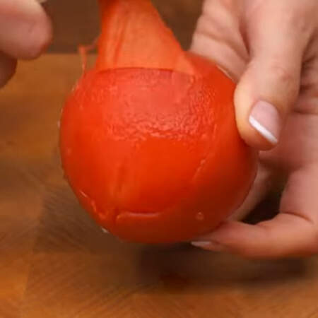 Теперь помидоры очень легко очищаются от кожуры. Подхватываем кожуру в том месте, где делали надрез и снимаем ее целыми лоскутами.