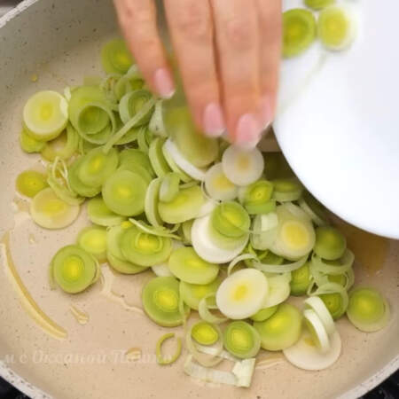 В сковороду с растительным маслом кладем нарезанный лук порей. Пассеруем его примерно 3-4 минуты до легкой золотистости. 