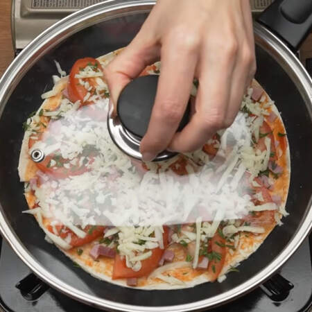 Сковороду накрываем крышкой и готовим пиццу примерно 5-7 минут. Будьте внимательны, готовьте на маленьком огне, чтоб лаваш не сгорел.
