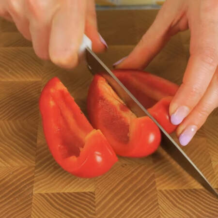 Один красный перец очищаем от семян и нарезаем полосками. Нарезанный перец перекладываем в миску с крабовыми палочками.