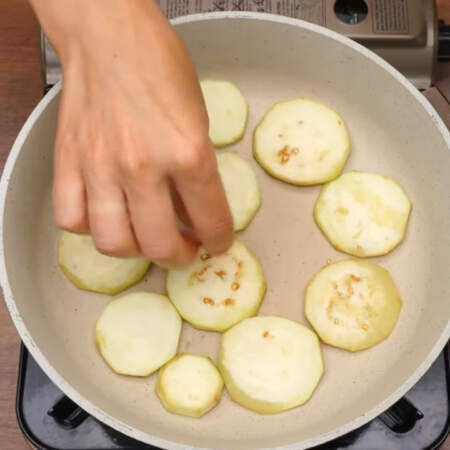 Подготовленные баклажаны выкладываем в один слой на сухую разогретую сковороду. Обжариваем баклажаны с двух сторон до золотистого цвета. 