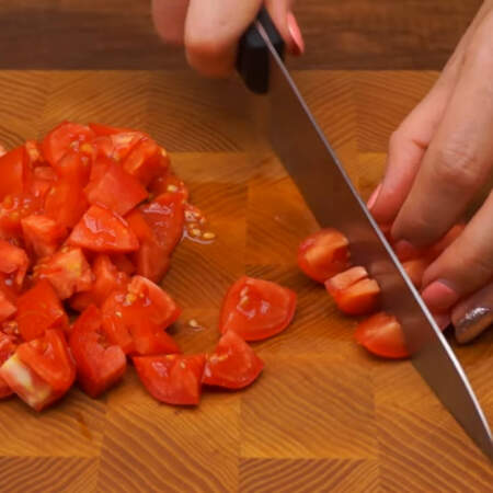 250 г помидоров разрезаем пополам, вырезаем плодоножку и нарезаем крупными кубиками.