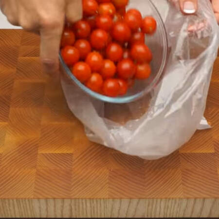 Пол килограмма уже вымытых помидоров черри пересыпаем в чистый пакет и распределяем их так, чтобы они лежали в один слой. 