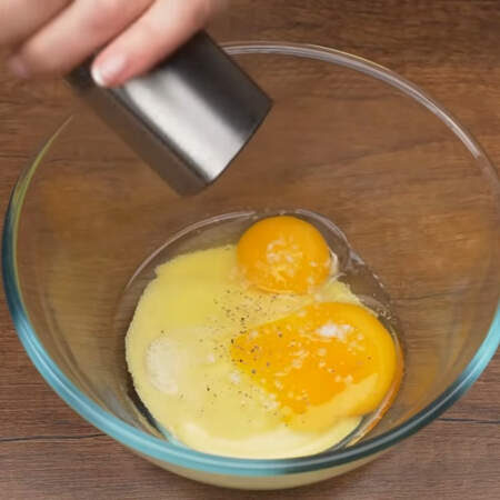 В миску насыпаем 50 г манки, разбиваем 2 яйца. Все солим по вкусу и перчим. 