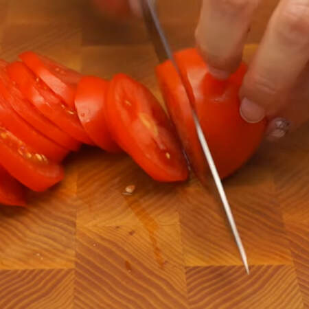 Примерно три помидора нарезаем пластинками.