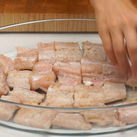 Форму для выпечки смазываем растительным маслом и выкладываем подготовленные кусочки рыбы кожей вниз.
