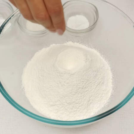 В отдельную миску просеиваем 275 г муки, добавляем щепотку соли, 1 ч. л. разрыхлителя для теста, 5 г ванильного сахара и 1/2 ч. л. соды.
