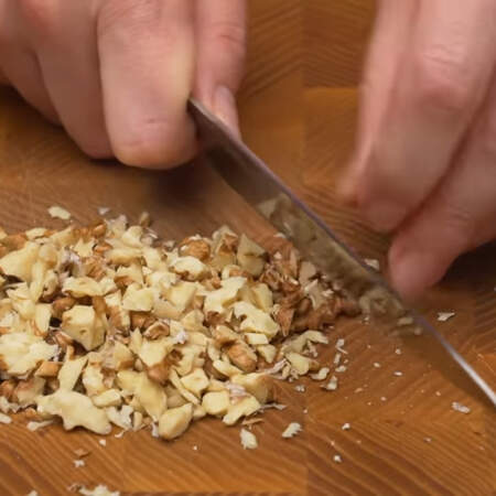 Пока подходит тесто приготовим крошку для посыпки пирожного.
Измельчаем ножом 30 г грецких орехов.