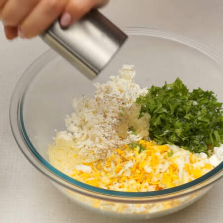 В миску кладем тертый сыр, яйца, сыр фета и нарезанную петрушку. Сюда же выдавливаем 1-2 зубчика чеснока. Все немного солим и перчим, не забываем, что сыры уже соленые. 