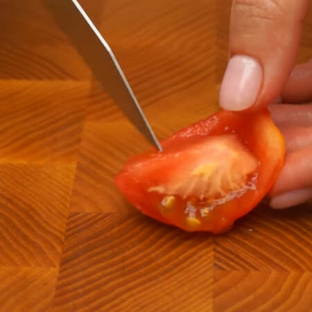 Для украшения будем использовать небольшой помидор. Разрезаем его на 4 части и удаляем семена. 