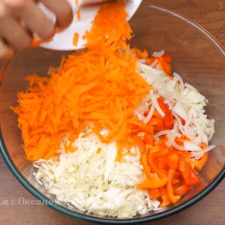 В большую миску кладем нашинкованную капусту, нарезанный перец, лук и тертую морковь.
Все перемешиваем. Я овощи не солю, так как капуста уже посолена.
