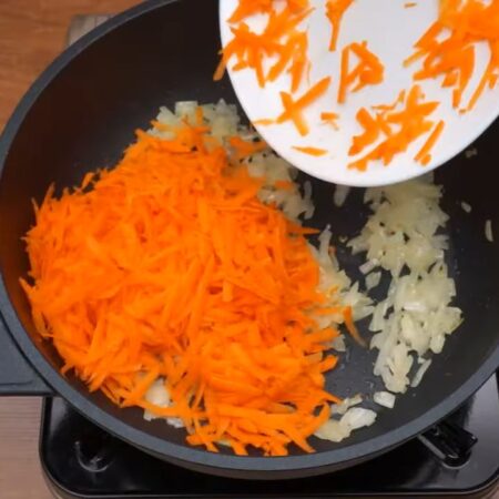 К луку  добавляем тертую морковь. Пассеруем еще несколько минут до мягкости морковки.