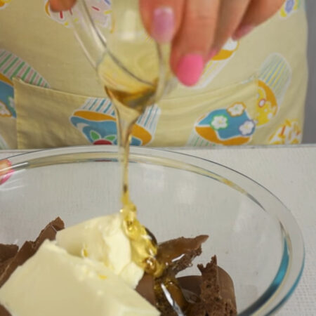 К шоколаду добавляем 100 г сливочного масла и 2 ст. л. инвертного сиропа. Инвертный сироп можно заменить медом. 