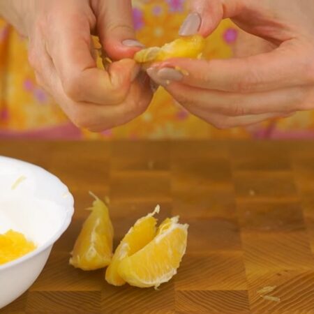 Апельсин чистим от оставшейся кожуры, разделяем на дольки и снимаем с долек все пленки. Крупные кусочки апельсина разделяем на более мелкие. 
