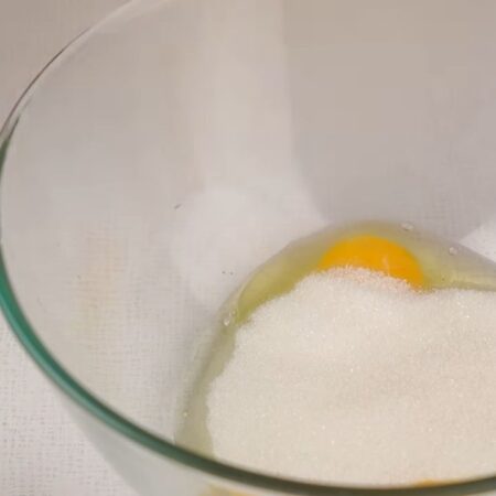 В отдельную миску разбиваем яйца и добавляем сахар.