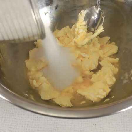 В масляно-яичную смесь добавляем 125 г сахара.