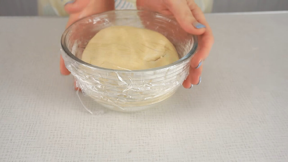 Тесто присыпаем мукой и формируем из него шар. Накрываем его пищевой пленкой и убираем в холодильник на 30 минут.