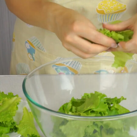 Пучок листьев салата, весом 100-150 г, рвем руками в большую миску, в которой будет удобно перемешивать салат. Также листья салата можно нарезать.