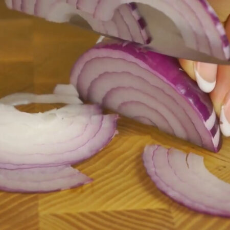 Половину красной салатной луковицы нарезаем тонкими полукольцами и тоже отправляем в миску.