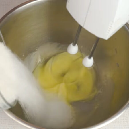 В другую миску разбиваем 1 яйцо и начинаем его взбивать. Постепенно насыпаем 100 г сахара. 