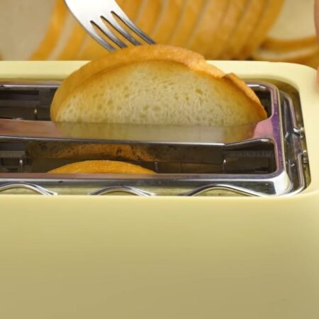 Сначала подготовим батон для бутербродов. Каждый кусочек хлеба нужно поджарить в тостере. Если у вас нет тостера, то поджарить хлеб можно на сковороде с небольшим количеством подсолнечного масла. 