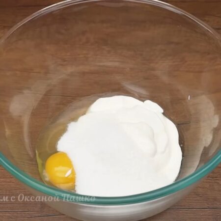 В миску разбиваем 1 яйцо и наливаем 150 мл сметаны любой жирности. Сюда же насыпаем 3 ст. л. с небольшой горкой сахара.