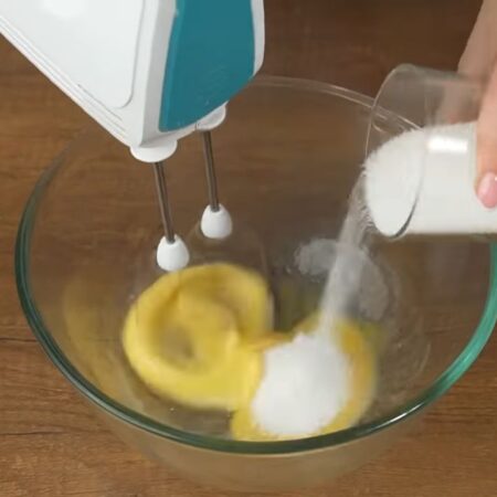 В миску разбиваем 1 яйцо. Начинаем взбивать и добавляем небольшими порциями 1/2 стакана сахара. 