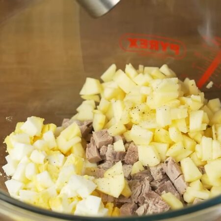 Складываем салат.
В миску кладем яйца, нарезанное мясо и яблоки. Салат немного солим и перчим черным молотым перцем. 