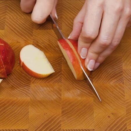 Два средних кисло-сладких яблока разрезаем на четвертинки и вырезаем серединку.  Четвертинку яблока разрезаем поперек, а затем нарезаем толстыми пластинками.
