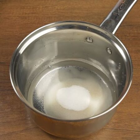 В миску наливаем пол стакана воды и насыпаем пол стакана сахара. Ставим на огонь. 