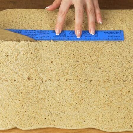 C остывших бисквитов снимаем пергаментную бумагу.
Каждый из бисквитов разрезаем вдоль на три одинаковых полосы. Должно получится 6 примерно одинаковых полосок бисквита шириной около 10 см.