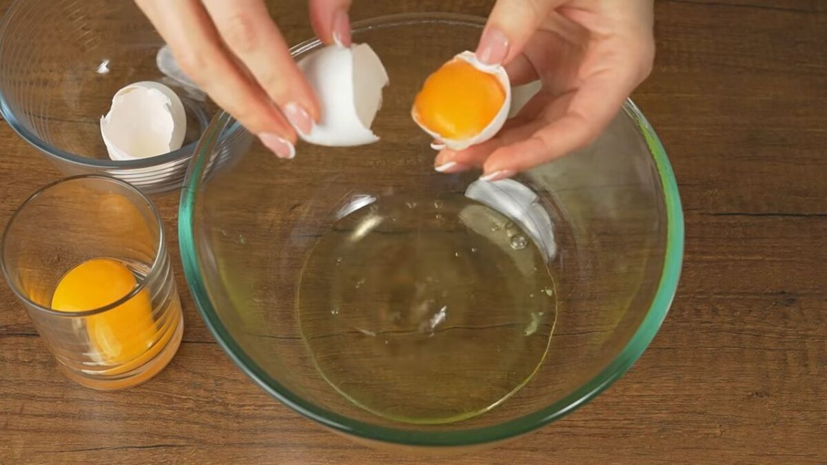 Три яйца разделяем на желток и белок. Белки выливаем в чистую и обязательно сухую миску, а желтки выливаем в отдельный стакан.
