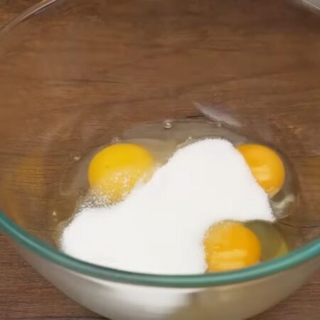 В отдельную миску разбиваем 3 яйца и насыпаем 5 ст. л. с горкой сахара.