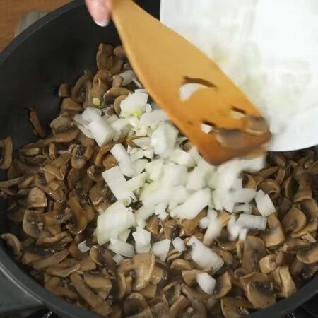  Лишняя жидкость испарилась, наливаем в сковороду к грибам немного растительного масла. Сюда же кладем нарезанный лук. 