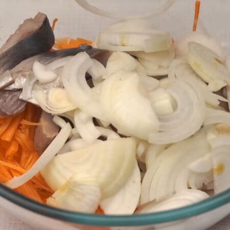 В миксу к натертой моркови добавляем кусочки сельди и нарезанный лук. 