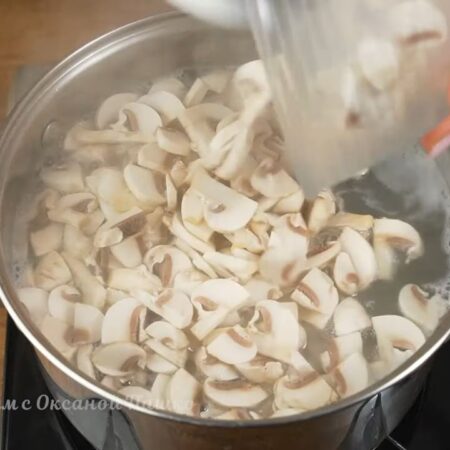 Картошка с рисом практически сварилась, добавляем в кастрюлю нарезанные грибы.