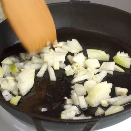 Нарезанный лук выкладываем на раскаленную сковороду с небольшим количеством растительного масла. Обжариваем до золотистости. 