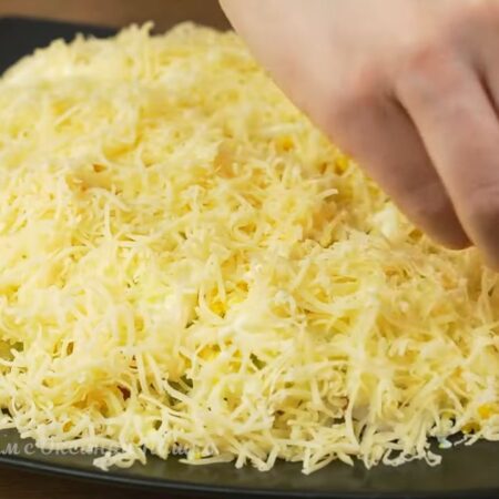Последним слоем выкладываем тертый сыр. Посыпаем им салат сверху и по бокам.