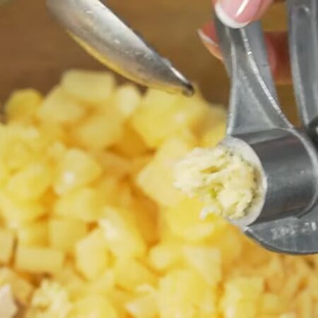 В большую миску кладем нарезанное куриное филе, тертый сыр и ананасы.
В салат добавляем 1 зубчик чеснока через пресс.