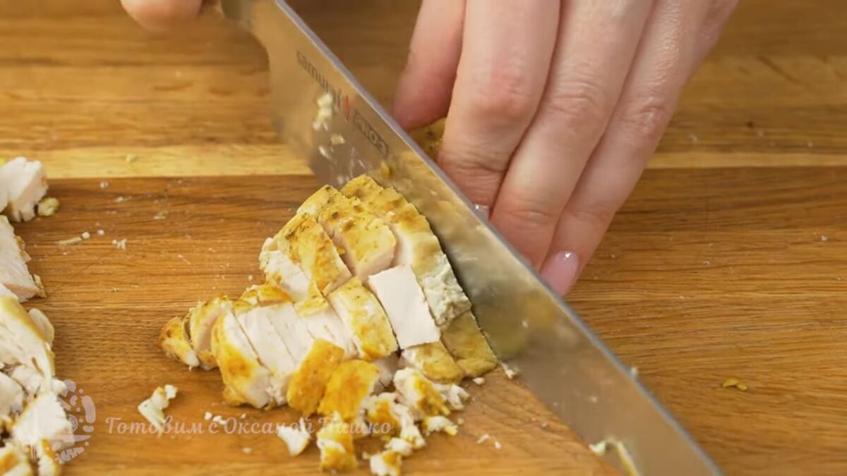 Остывшее куриное филе нарезаем сначала вдоль на пластинки, а затем нарезаем небольшими кубиками. По желанию, для салата можно использовать копченую куриную грудку.
