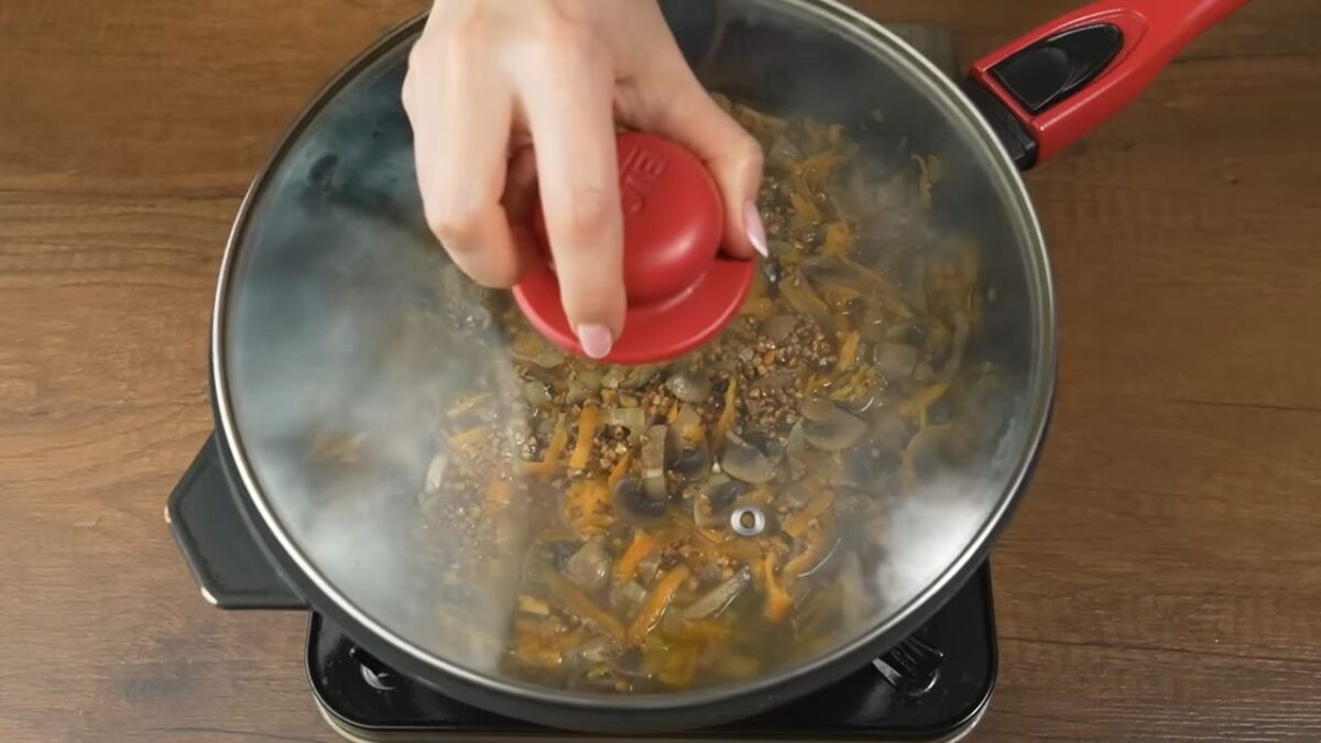  Сковороду накрываем крышкой. Когда вода закипит огонь уменьшаем до минимального. Готовим гречку с грибами примерно 15-20 минут. Пока вся вода не впитается в гречку.
