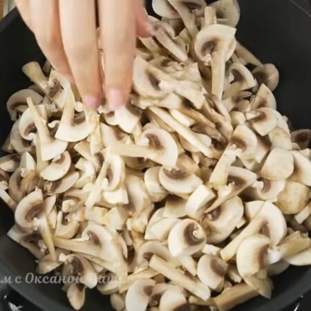 В глубокую сковороду кладем нарезанные грибы. Готовим их на самом большом огне до испарения всей жидкости. Периодически грибы перемешиваем.
